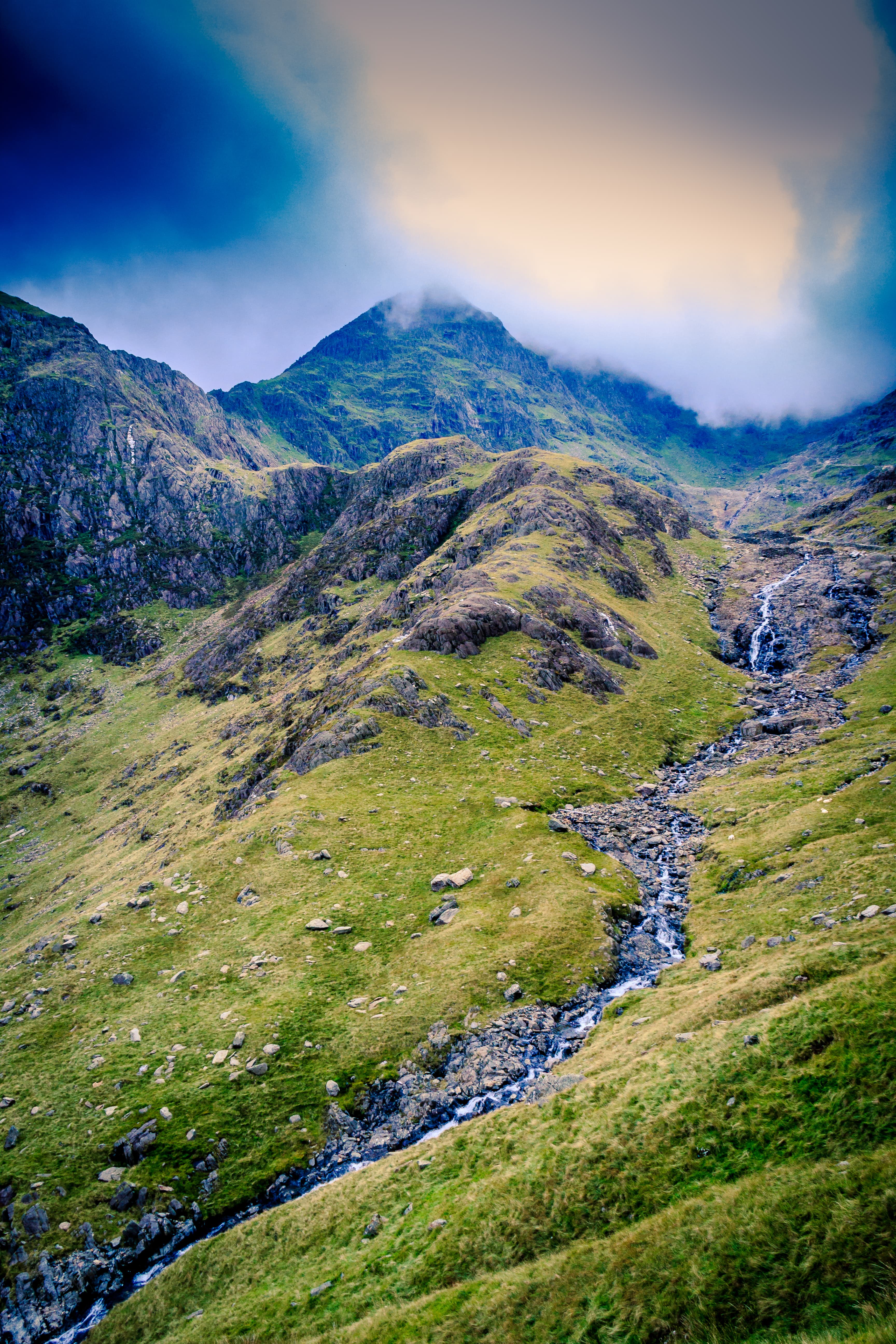 Mountain stream under heavy cloud.