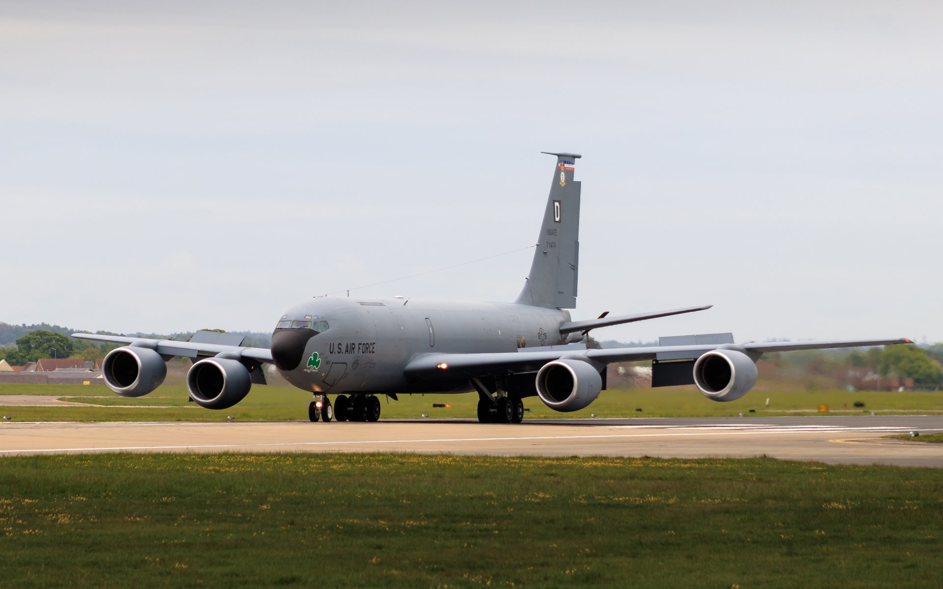 This photograph captures the grandeur of a U.S. Air Force KC-135 Stratotanker, a iconic aerial refueling aircraft, in a moment of serene anticipation on the runway. The soft, diffused light of a overcast sky enhances the aircraft's sleek, metallic gray finish, creating a perfect balance of industrial strength and graceful elegance. The composition, with the aircraft positioned slightly off-center, draws the viewer's eye across the frame, evoking a sense of motion and readiness. This image's aesthetic appeal lies in its ability to convey a power and precision of military aviation, making it a perfect focal piece for any executive office or modern gallery wall. Display this image to inspire admiration for the art of flight and the dedication of those who serve.