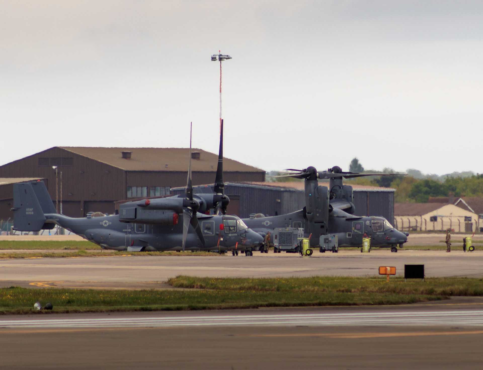 This photograph captures the serene presence of military helicopters on a tarmac, bathed in soft, natural light that enhances their sleek, dark gray surfaces. The composition, with the helicopters positioned centrally, draws the viewer's eye across the expansive runway, creating a illusion of motion and readiness. The muted tones and balanced lighting evoke a calm precision of military operations, making this image a compelling piece for any aviation enthusiast or professional seeking a perfect blend of functionality and artistry. Ideal for placement in a living room as a focal point, or in an executive office to inspire a sense of order and discipline.