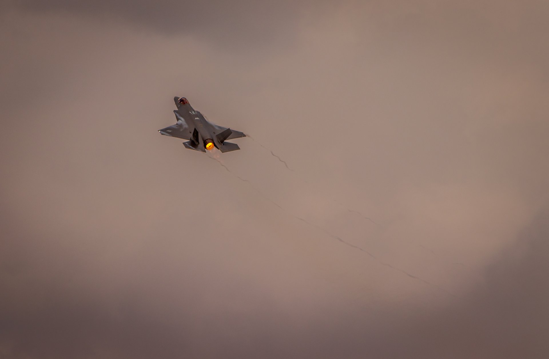 This photograph captures the majestic flight of a F-22 Raptor, its sleek form slicing through the sky with a precision of a modern fighter jet. The muted tones of the aircraft contrast beautifully with the soft, diffused light of the overcast sky, creating a perfect balance of power and tranquility. The composition, with the jet positioned centrally, draws the viewer's eye directly into the heart of the action, evoking a awe and admiration of aviation. This image's aesthetic appeal lies in its ability to convey the quiet strength and elegance of advanced military technology, making it a perfect focal point for any executive office or a modern gallery wall where it can inspire and captivate.
