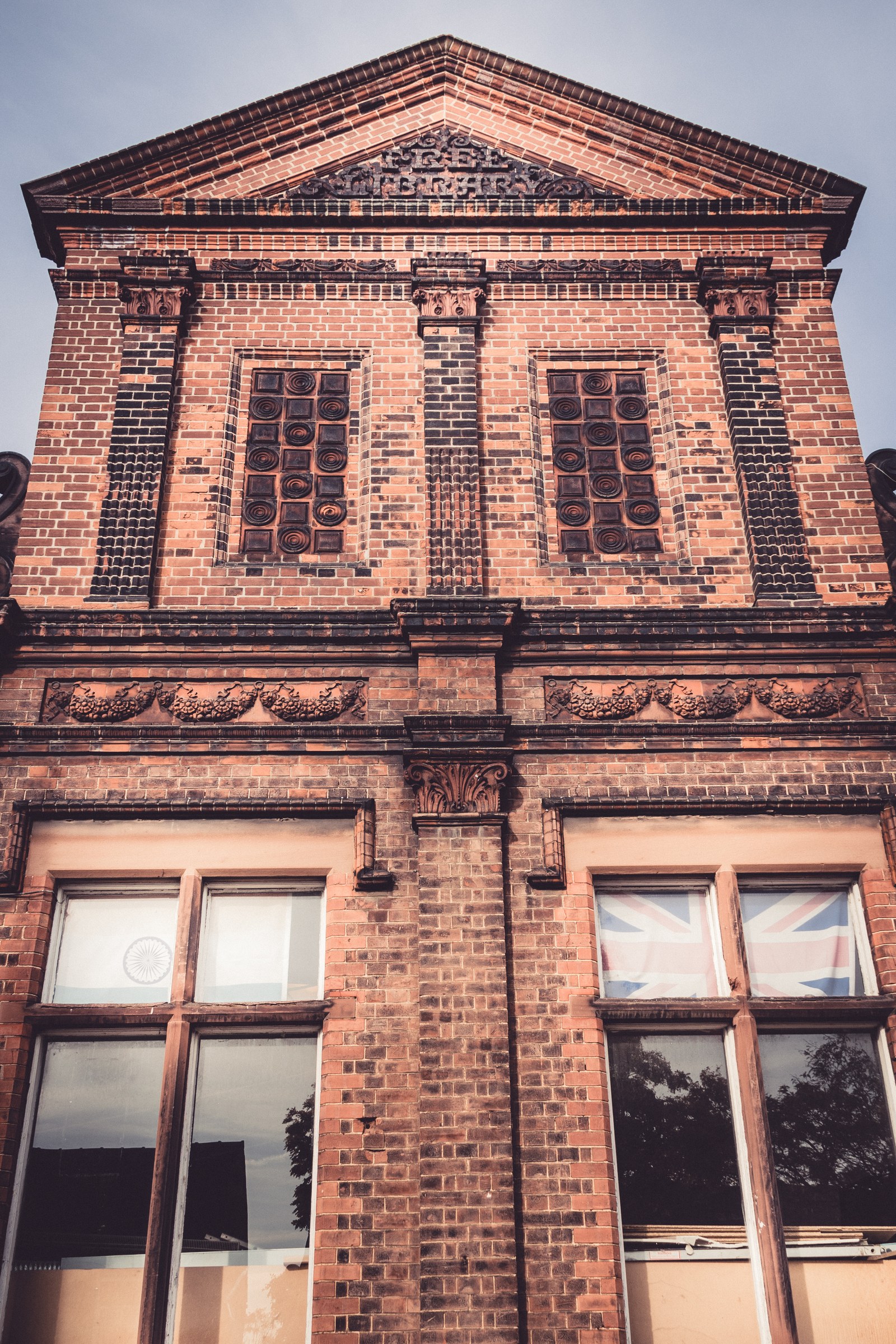 This photograph captures the timeless beauty of a brick facade, bathed in warm, golden light that accentuates its intricate architectural details. The symmetrical composition and the play of light and shadow create a perfect balance, evoking a feeling of history and sophistication. The rich, earthy tones of the bricks make it a perfect focal point for any modern gallery wall, or as a centerpiece in executive office, where it can inspire a sense of timeless elegance and professionalism.