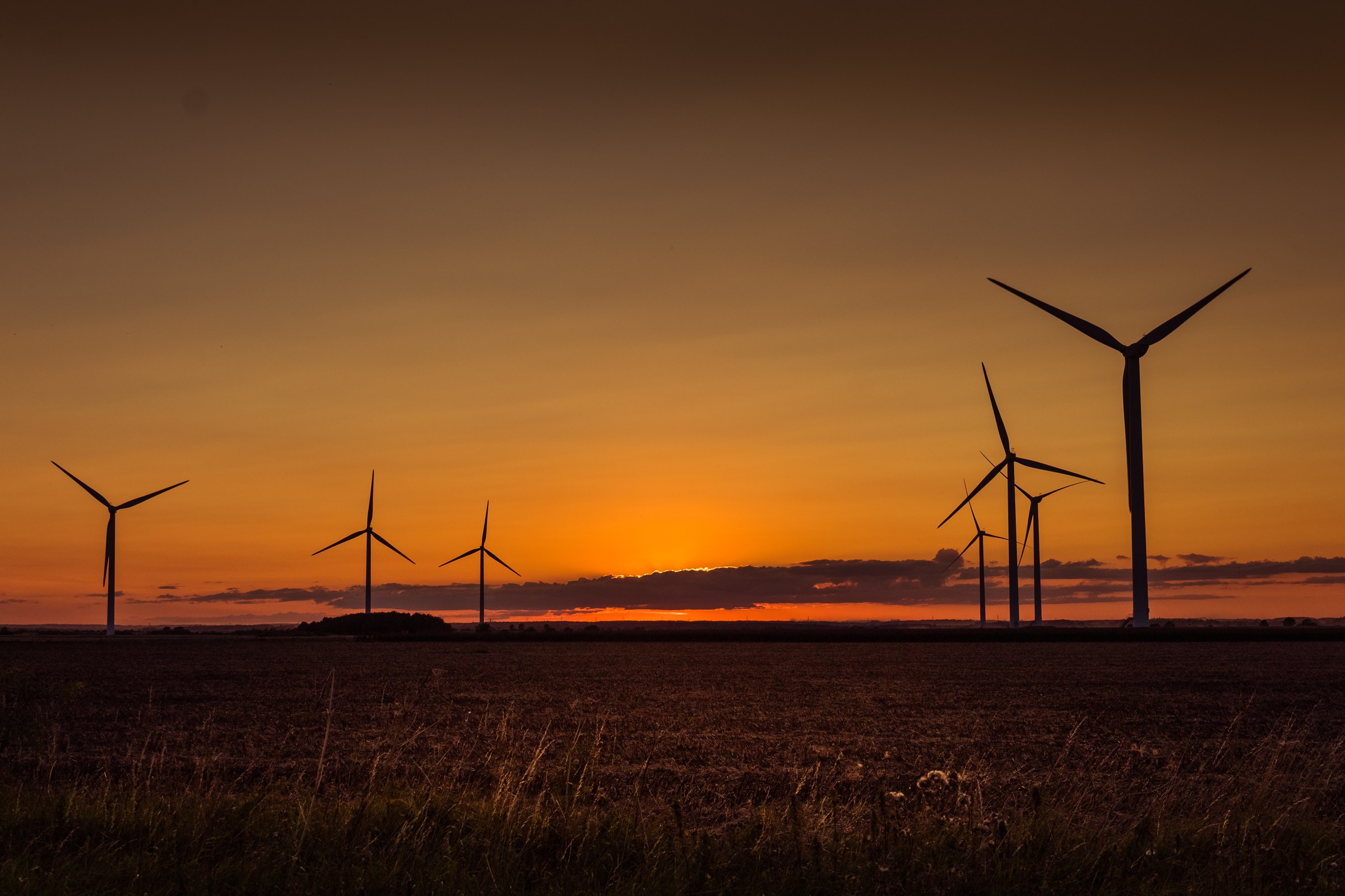 This breathtaking photograph captures the tranquil beauty of wind turbines silhouetted against a vibrant hues of a sunset. The warm, golden tones of the sky contrast beautifully with the dark outlines of the turbines, creating a perfect balance of nature and technology. The composition, with the turbines arranged in horizon, draws the eye across the canvas, evoking a sense of peace and progress. This aesthetic appeal lies in its ability to inspire and uplift, making it a ideal focal piece for any modern living room or executive office. Hang it in a corner of your living room to bring a touch of the outdoors in, or in your office to inspire innovation and calm.