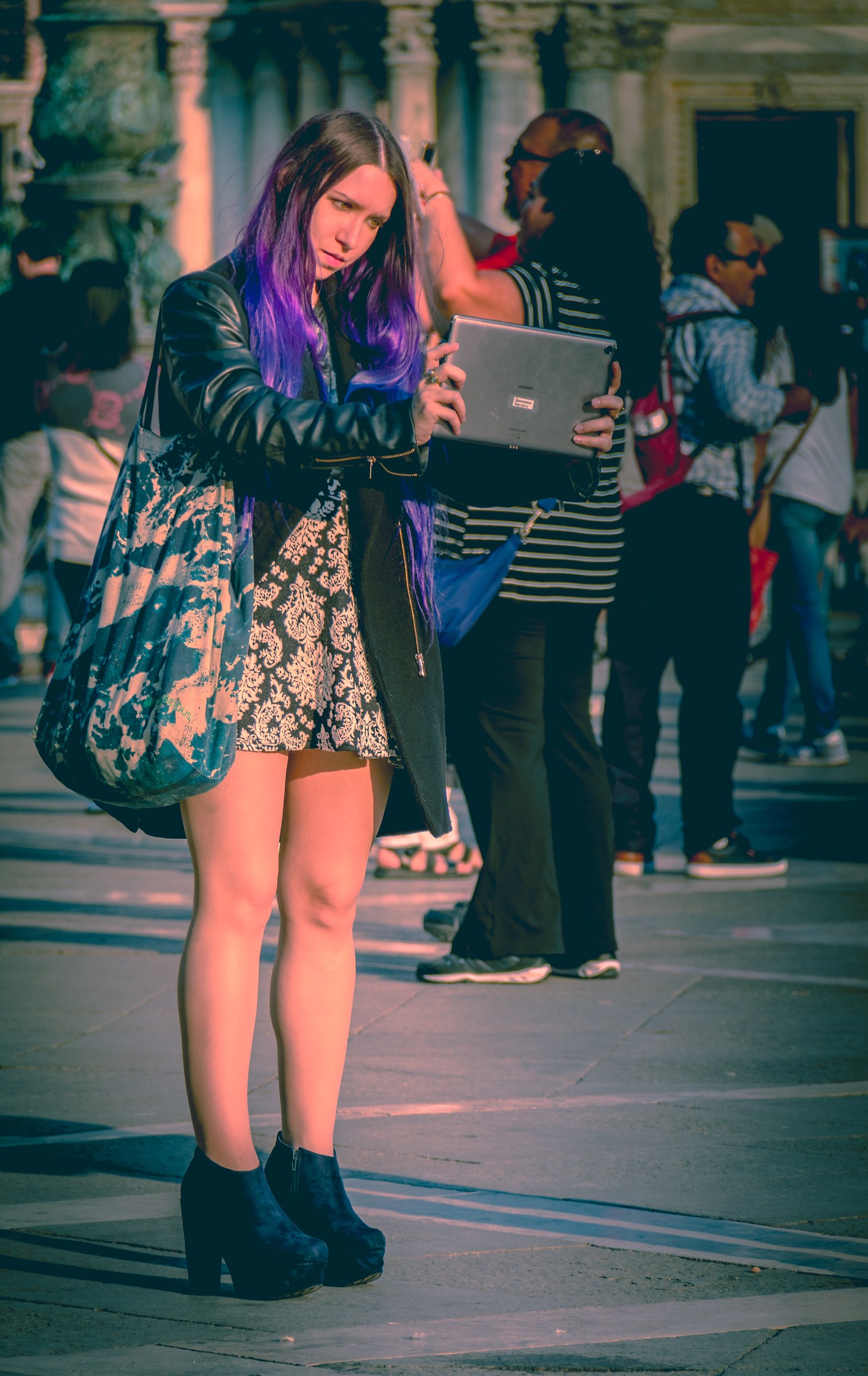 This photograph beautifully captures the vibrant energy of an urban setting, where a subject's striking purple hair and stylish attire contrast against the warm, golden hues of the evening light. The composition, with the subject in focal point, draws the viewer into the scene, while the blurred background of bustling pedestrians adds depth and context. The interplay of light and shadow enhances the mood, creating a perfect balance of modernity and mystery. This aesthetic appeal lies in its ability to evoke a feeling of being part of a moment, making it ideal for a living room as a centerpiece of a space, or for the executive office to inspire creativity and a urban spirit.